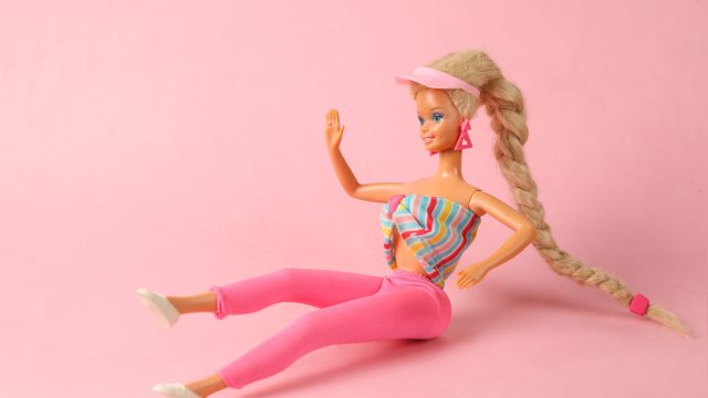 Barbie sitting down on a field of pink
