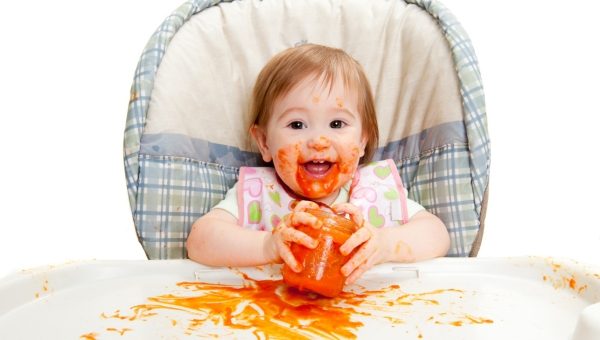 Baby smiling with a jar a baby food